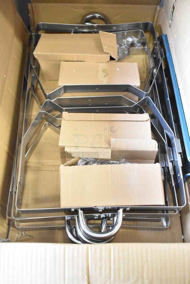 13 new scratch and dent items including stainless steel drop-in bins and metal chafing dish frames, packaged in a box.
