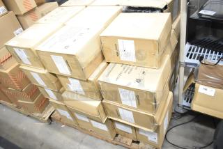 Stack of boxes containing Amazon Basics 12-sheet cross-cut paper shredders, brand new with some boxes showing scratches and dents.