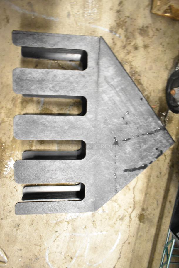 Two-tier lot item, includes black metal beverage holder dispenser with slots, shown on worn floor. Additional items not visible.