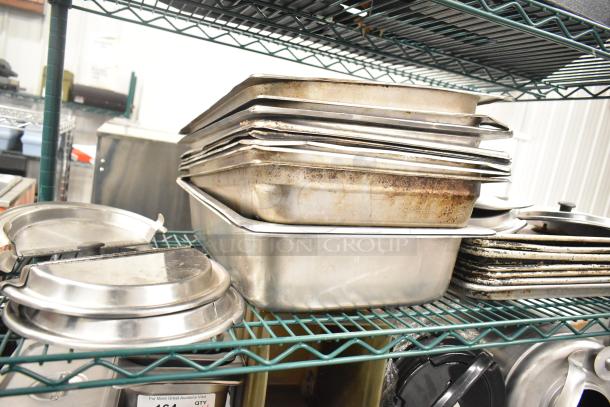 Two-tier lot of stainless steel drop-in bins, metal pans, and lid organizers. Visible wear on some items. Auction item.