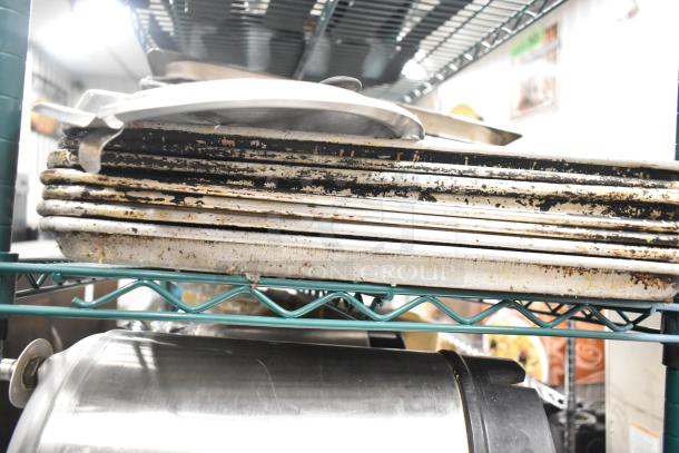 Two-tier lot with stainless steel drop-in bins, metal pans, and lid organizers. Visible wear and patina on items.