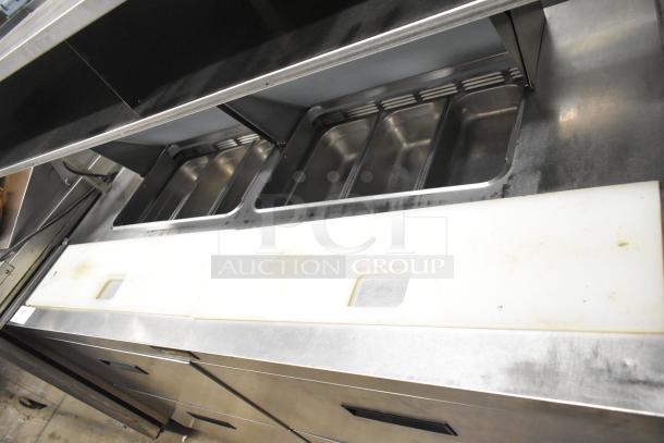 Delfield UCD4464N-12-DD5 stainless steel prep table, featuring 4 drawers, over shelf, bain marie top, on commercial casters.