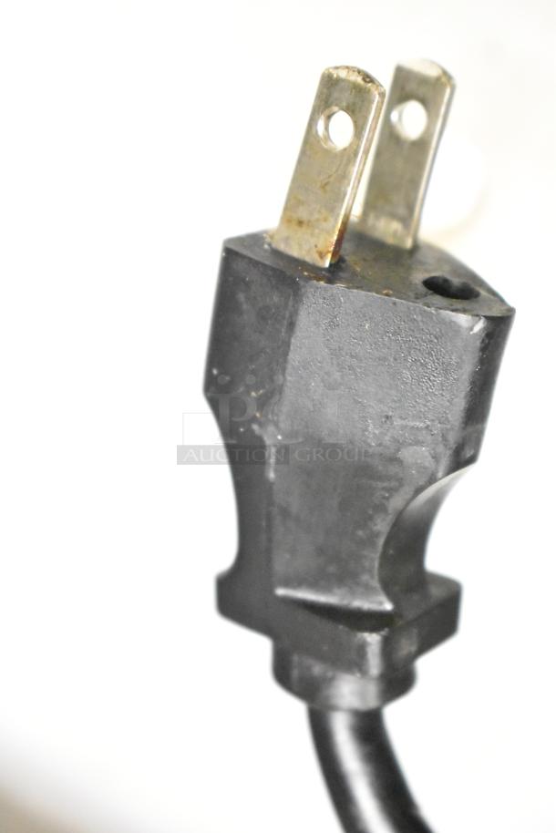 Close-up of a two-pronged plug for the Delfield UCD4464N-12-DD5 prep table, showing some wear, suitable for 115V outlets.