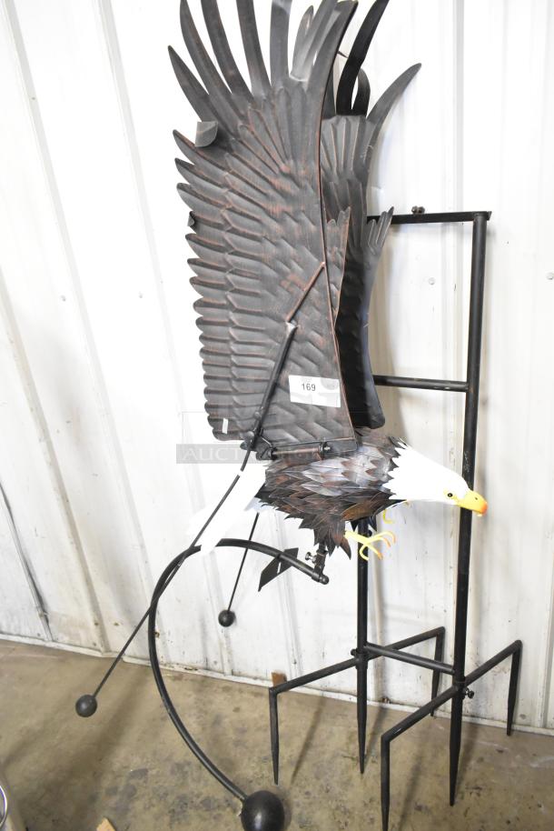 Decorative metal eagle with intricate feather details on a sturdy black stand, item tag marked 169, good condition.