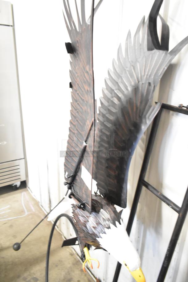Decorative eagle sculpture on a stand, detailed metal feathers, life-size, pristine condition, striking design.