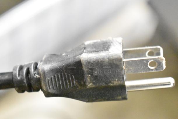 Alt text: Close-up of a power plug for the SL55R commercial cooler, showing two prongs and a grounding pin.