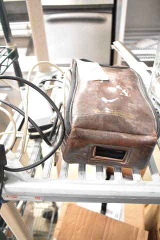 Leather case containing 1062 MiniTemp Calibrator, includes visible cables. Case shows wear.