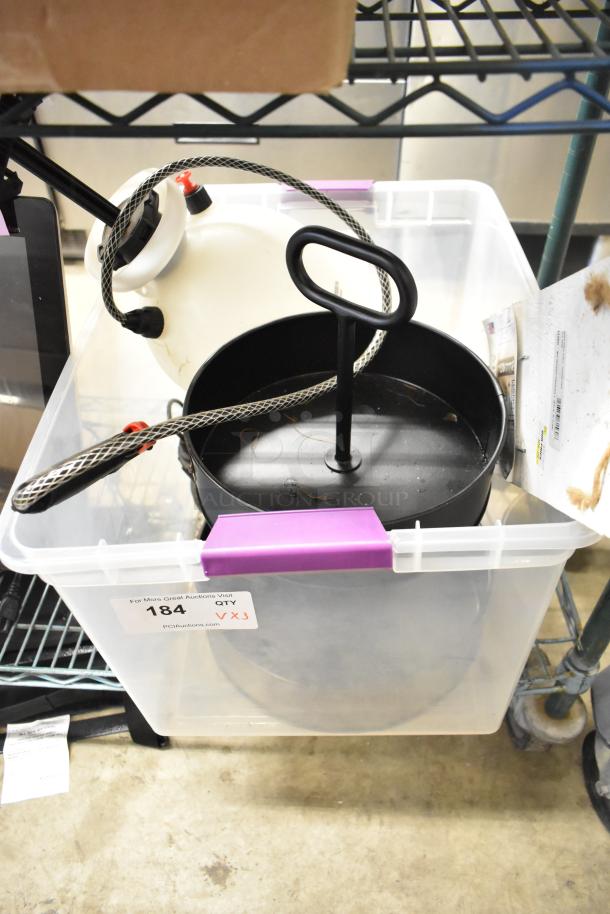 Clear storage bin with a Roundup sprayer, black cupcake stand, and fall-themed sign. Auction tag marked "184, QTY 3X".