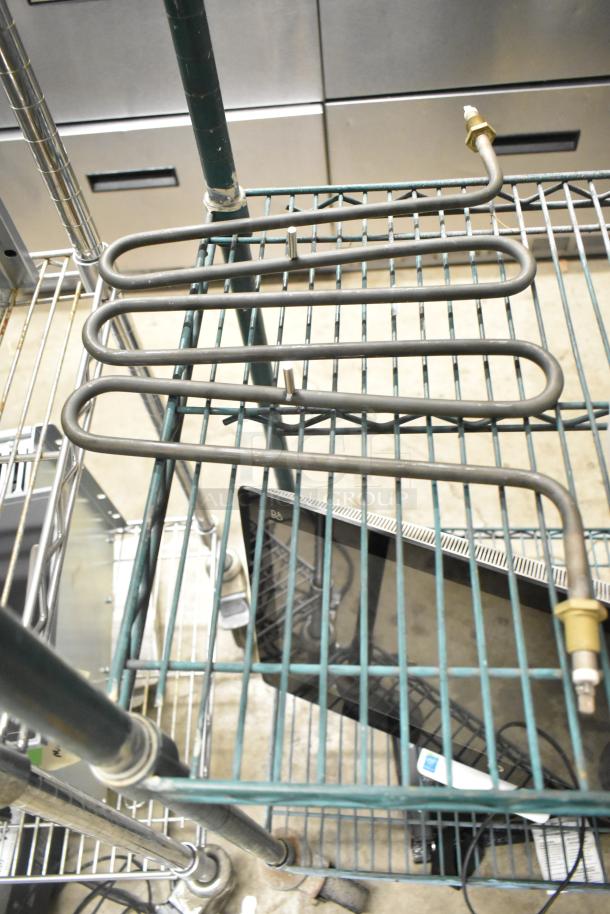 Three assorted auction items, including a metal burner. Items are placed on a wire shelf. Condition appears fair.