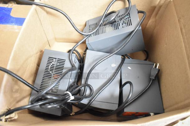 Box containing Powervar power conditioners with visible cords and plugs, part of a 10-item auction lot including Epson printer.