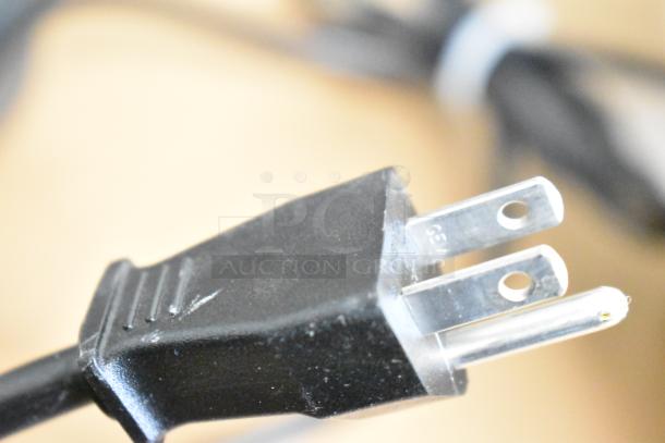 Close-up of a standard three-prong black electrical plug attached to the auction items including Epson printer and Powervar conditioners.