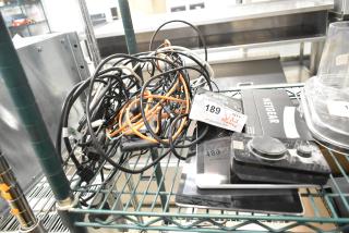 Assorted auction items: Netgear box, Verifone reader, Apple iPad, Astro Mixamp, Windows tablet. Includes tangled cables. Lot tag visible.