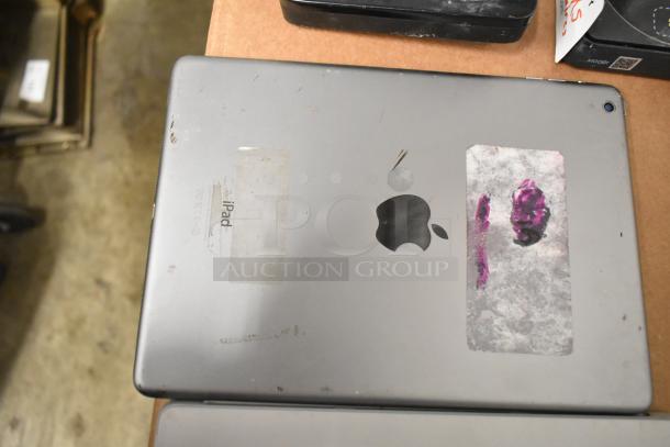 Used Apple iPad with visible wear and labels. Includes Netgear box, Verifone reader, Astro Mixamp, Windows tablet.