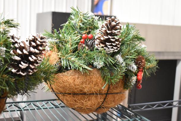Artificial pine arrangement in a woven basket, featuring pinecones and red berries. Excellent condition, decorative faux plant.