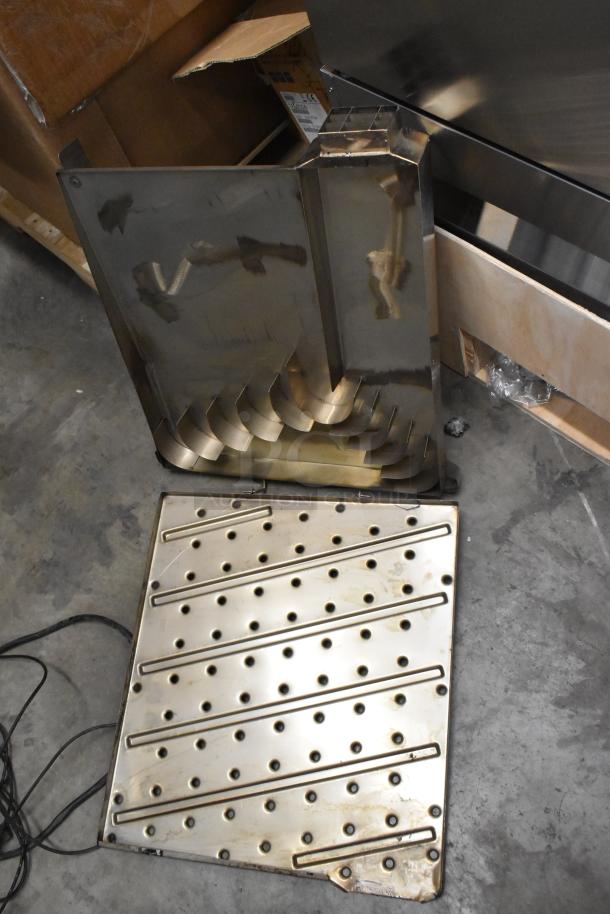 Two metal units with perforated and contoured designs, used condition, includes cardboard packaging. Perfect for industrial use.