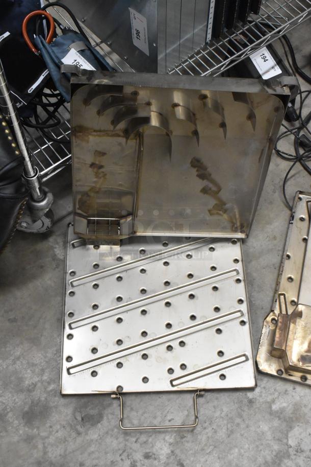 Two metal units with perforated surfaces and handles, in good condition, on a gray concrete floor. Store labels visible.