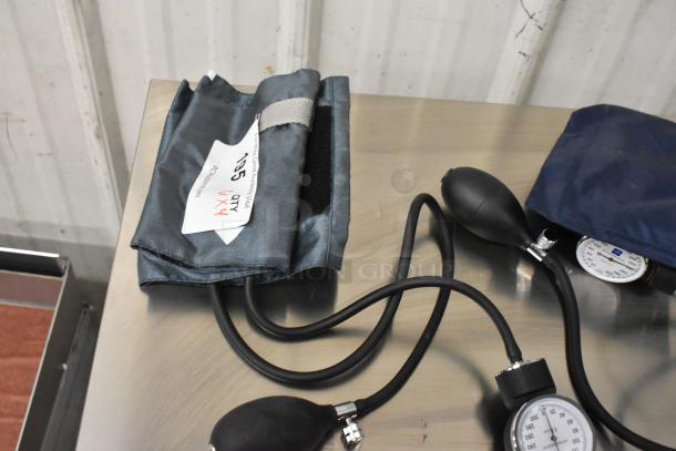 Four blood pressure cuffs on a table, varying sizes, with pressure gauges and pumps; label indicates quantity 4.