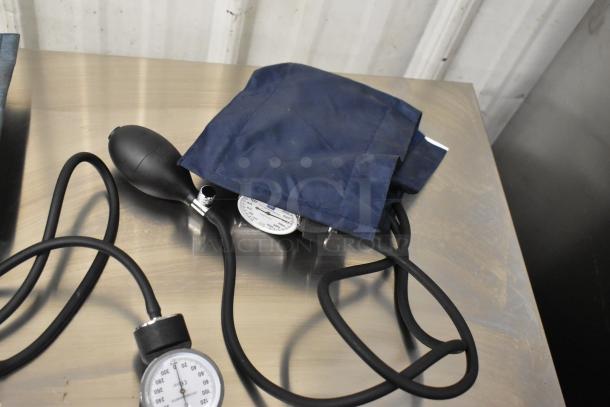 Four various blood pressure cuffs with black inflation bulbs and analogue gauges, in used condition. Suitable for medical use.