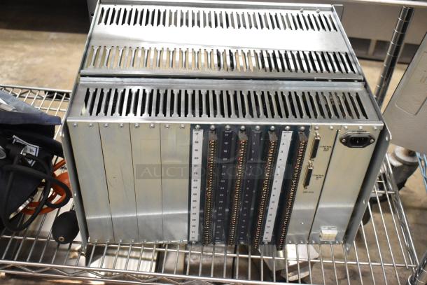 Sigma Electronics ADF-64A Unit, metal casing, multiple input/output slots, power controls, on wire rack, good condition.
