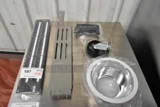 Five assorted items including a caster, metal panels, and a shiny metal bowl. Includes measuring sticks. Labeled for auction.