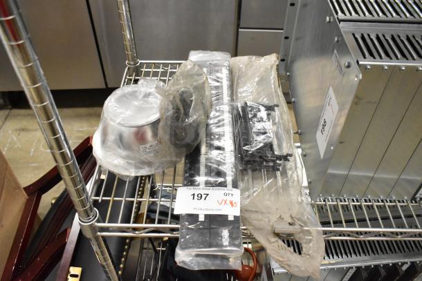 Five assorted items including a metal caster, industrial panels, and a metal bowl in plastic wrap on a wire rack. Auction tag reads "197."