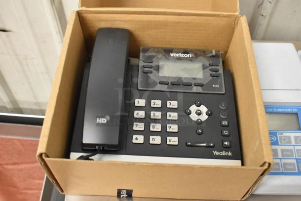 Auction items including a Verizon corded office telephone, Vtech baby monitor, and two Hach 2100P turbidimeters in box.