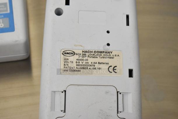 Two Hach 2100P turbidimeters, label showing 6-9V, 4 AA batteries, serial number 990200020679.