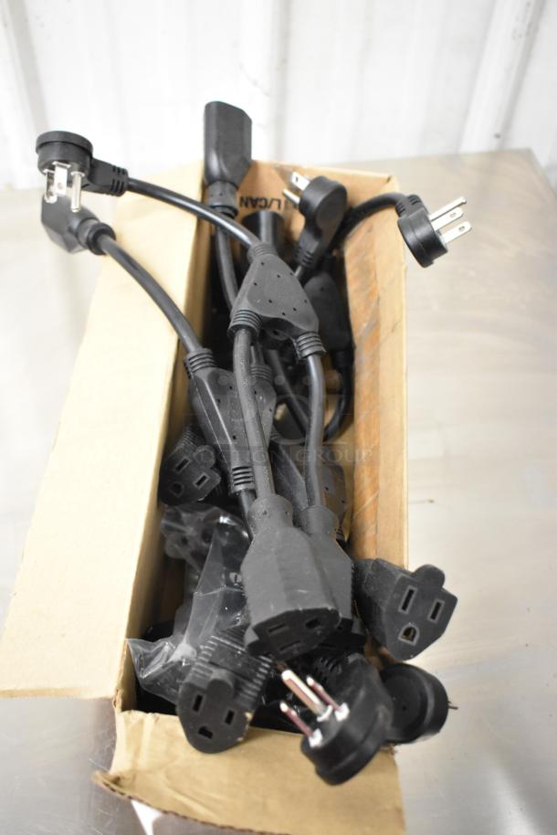 Box of assorted black power cables with multiple connectors, including Siemens TRI-R unit, in fair condition.