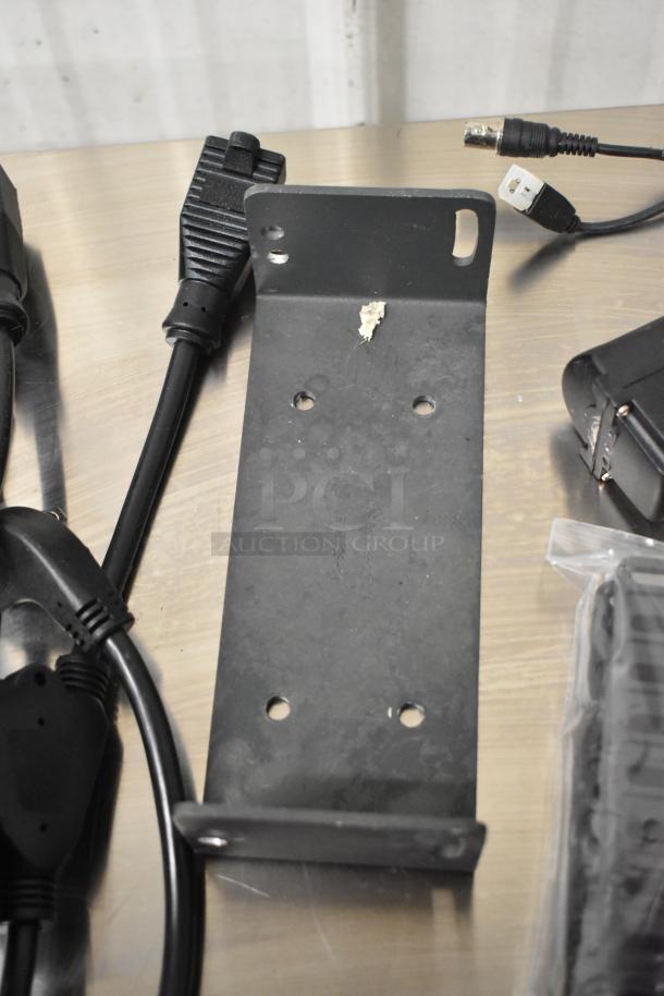 Lot of various items including black wires and a Siemens TRI-R unit on a table, showing connectors and a metal bracket.