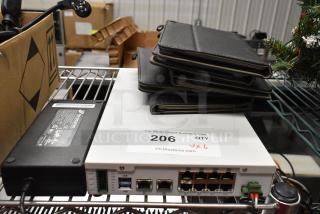 6 various items, including Avigilon VMA-ENVR1-8P8 NVR in good condition, with stacked black cases, visible label "206 QTY."