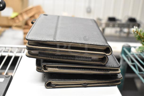 Stack of black leather cases, possibly for electronic devices, in good condition. Part of an auction lot with Avigilon NVR.