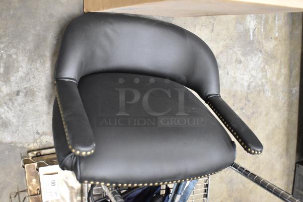 Black upholstered chair with nailhead trim, upholstered armrests, and curved backrest. Condition appears good; no visible tags.