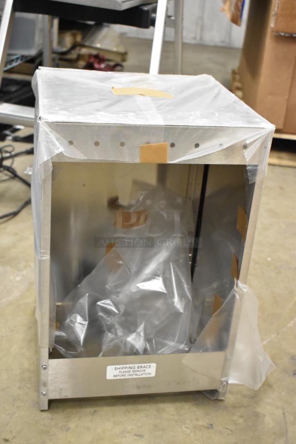 Metal box, new condition, partially covered with protective plastic. Label reads "SHIPPING BRACE - PLEASE REMOVE BEFORE INSTALLATION."