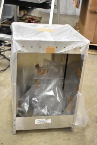 Metal box, new condition, partially covered with protective plastic. Label reads "SHIPPING BRACE - PLEASE REMOVE BEFORE INSTALLATION."