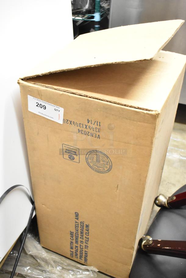 Cardboard box labeled with auction number 209, partially open. Contains a metal box. Box shows handling care instructions.