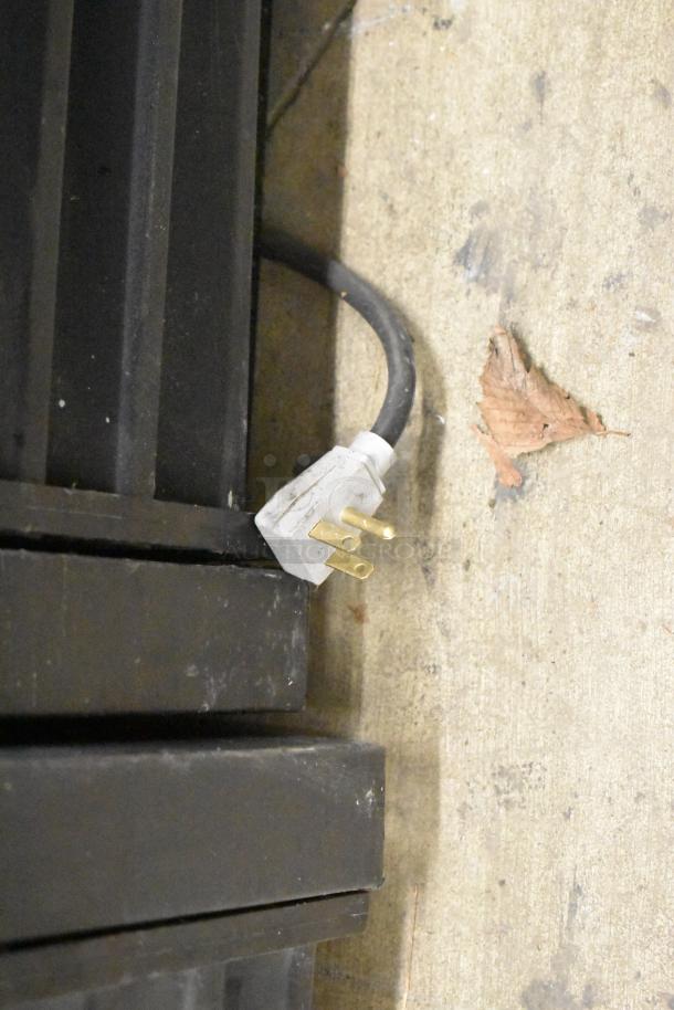 True GDM-41SL-60-LD cooler power plug detail, showing three-prong plug, attached to a black metal base.