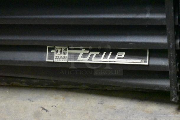 True GDM-41SL-54-LD cooler label showing brand logo on metal surface, commercial cooler model.