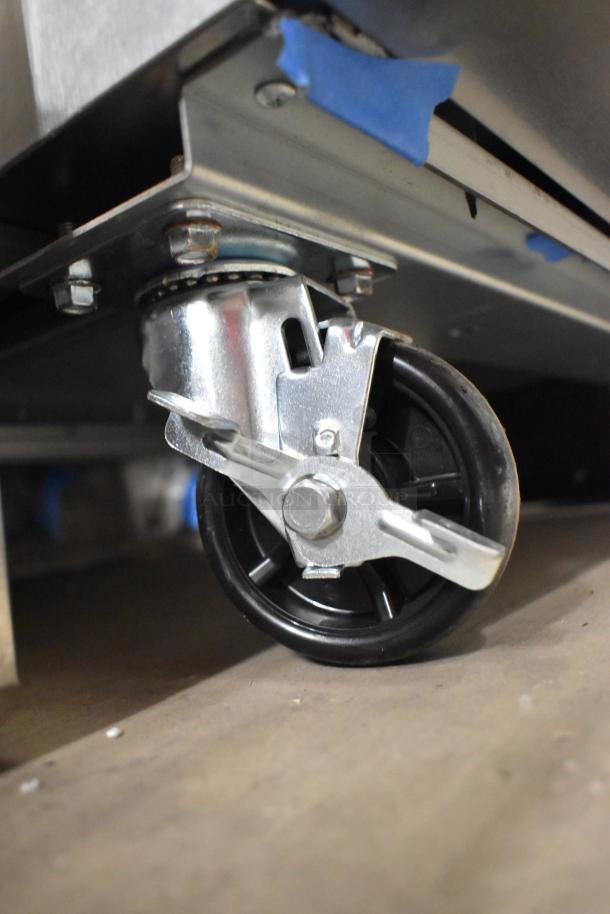 Brand new Avantco 178A23RHC cooler caster detail, showing robust metal construction and swivel capability.