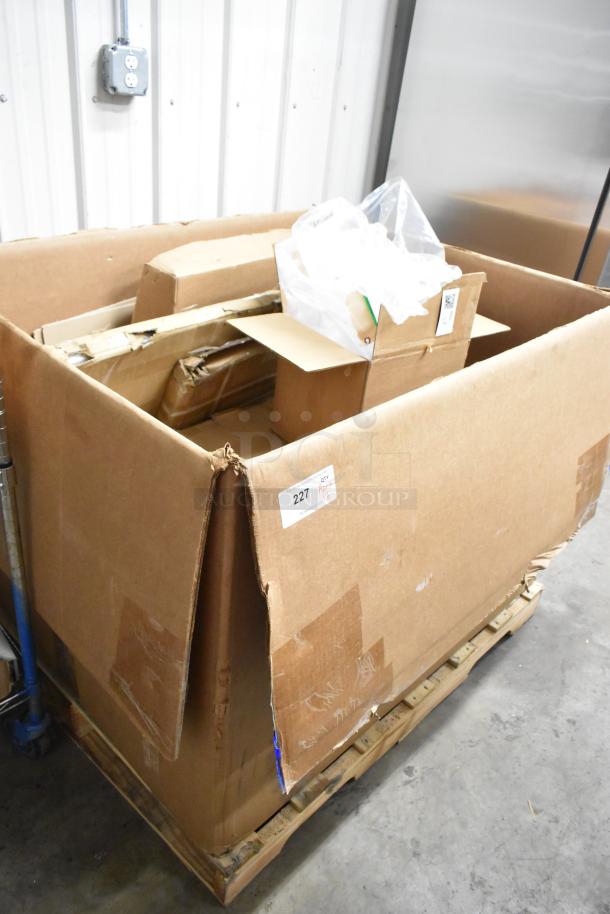 Cardboard box containing new scratch and dent items, including Regency table tops and shelves. Box marked with label "227."