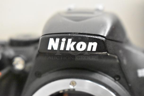 Nikon D3500 digital camera body, no lens. Close-up of Nikon branding on camera body, appears in good condition.