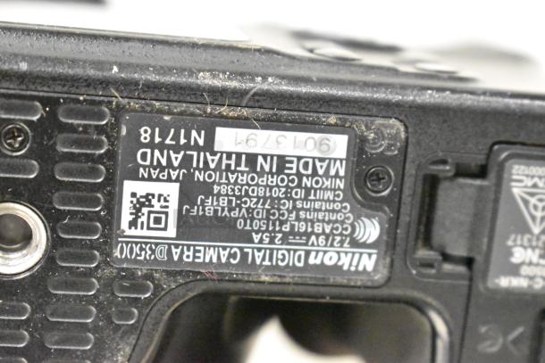 Nikon D3500 digital camera, no lens. Underside label shows model info and manufacturing details, "Made in Thailand."