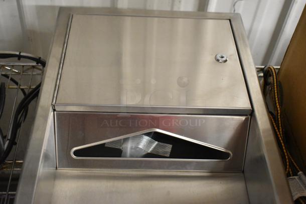 Stainless steel wall mount paper towel dispenser and trash can with locking lid, in good condition, keyhole visible.