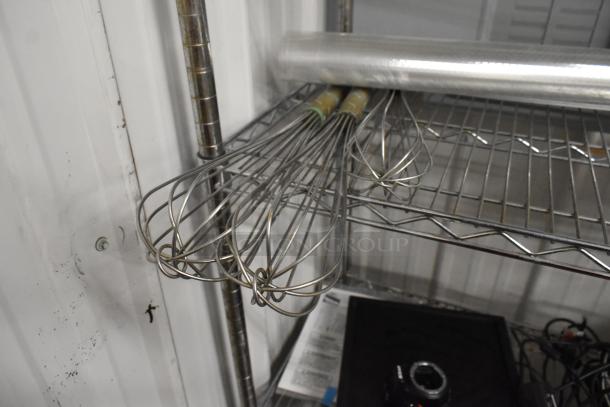 Whisks on metal shelf, part of tiered lot with poly bins and Detecto produce scale. Items in used condition.
