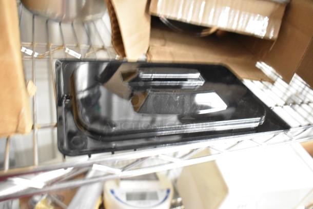 Lot of items including a black metal panel on a shelf, surrounded by boxes. Contains ice melt and utensils. Mild wear.