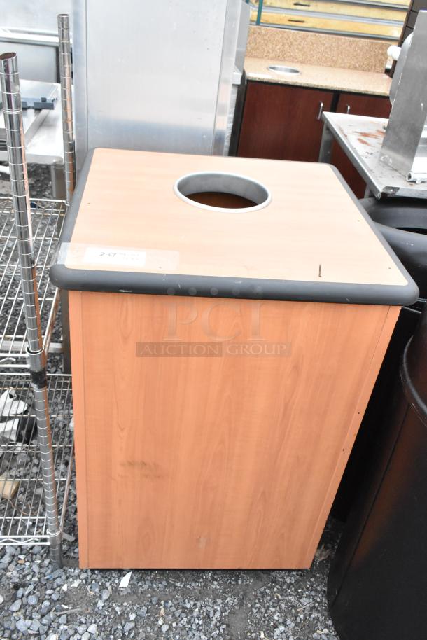 Three trash can shells; two black, one wood-patterned. Visible wear. Tag reads “237”.