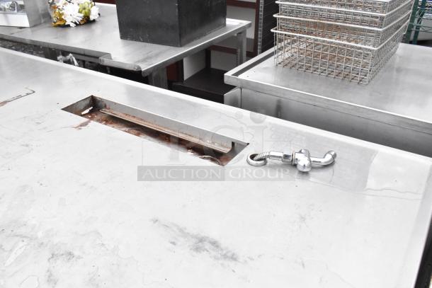 Stainless Steel Soda Station Table with a rectangular cutout and mounted pipe, showing wear and surface marks.