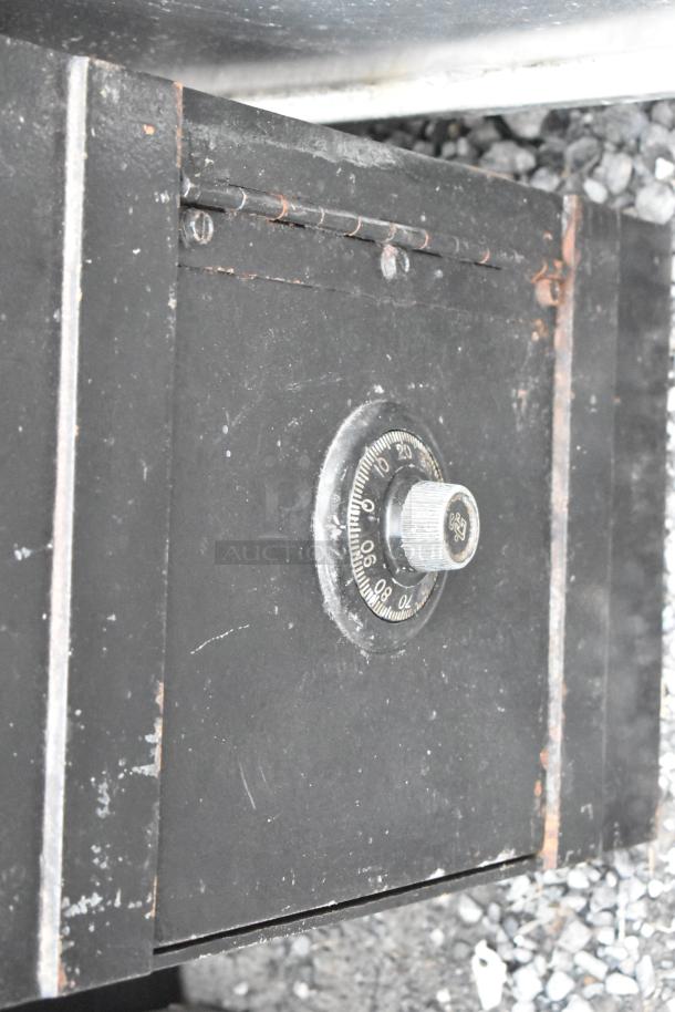 Black metal single compartment safe with combination dial, used condition, no combination provided.