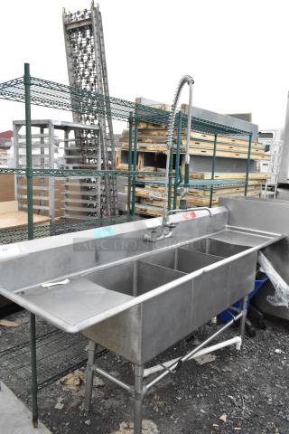 Stainless steel 3 bay sink with dual drain boards, commercial use, durable construction, good condition, visible faucet.