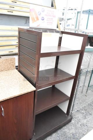 Wood pattern shelving unit with three shelves, brown finish, vertical side panels, minor surface wear.