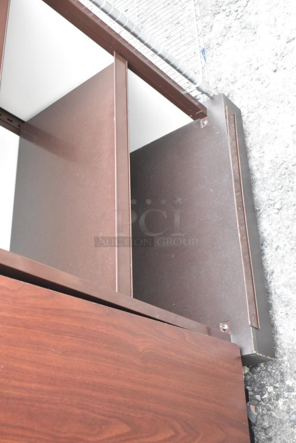 Wood pattern shelving unit with dark brown finish, two shelves visible. Mild wear on edges. Ideal for home or office use.